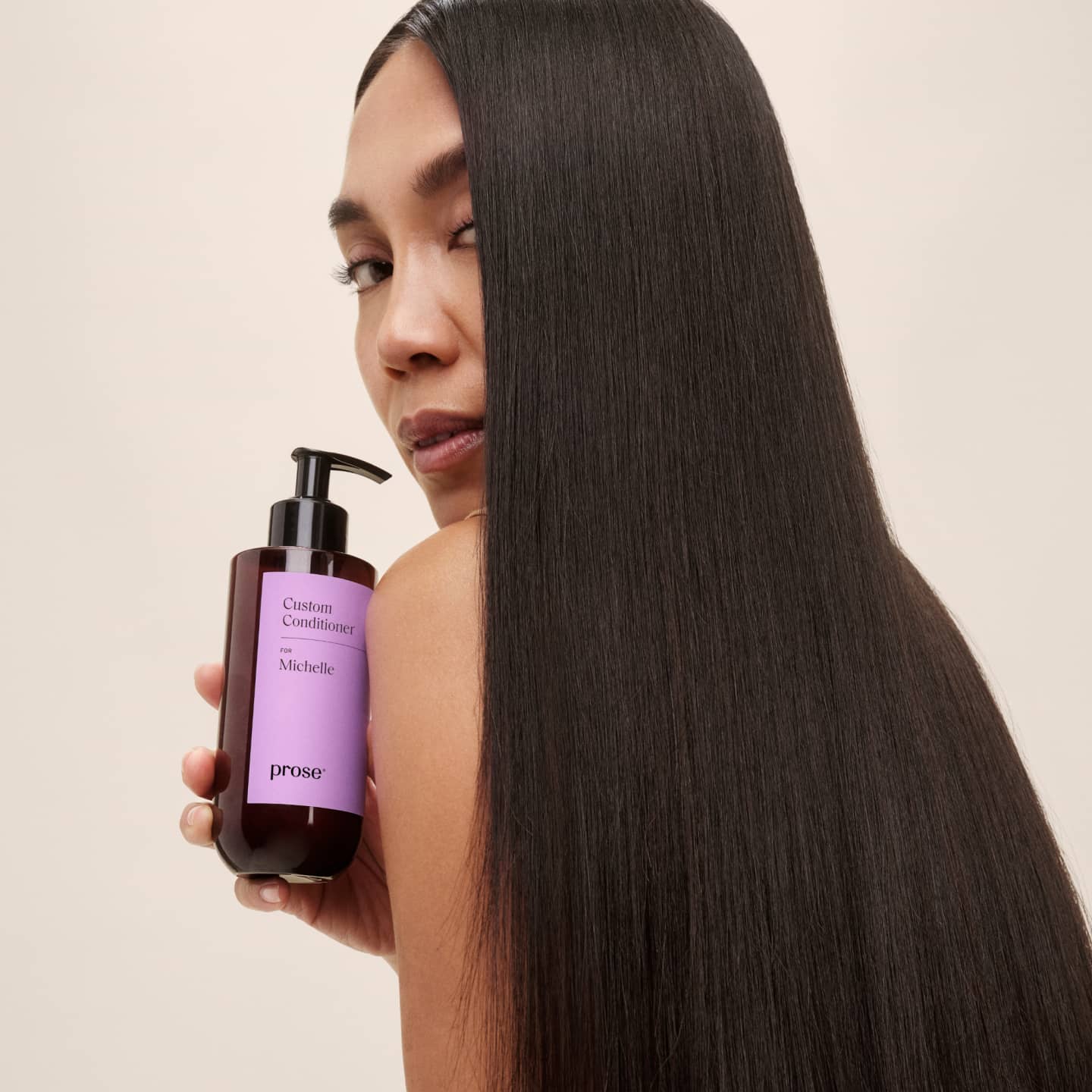Prose model posing with bottle of custom conditioner