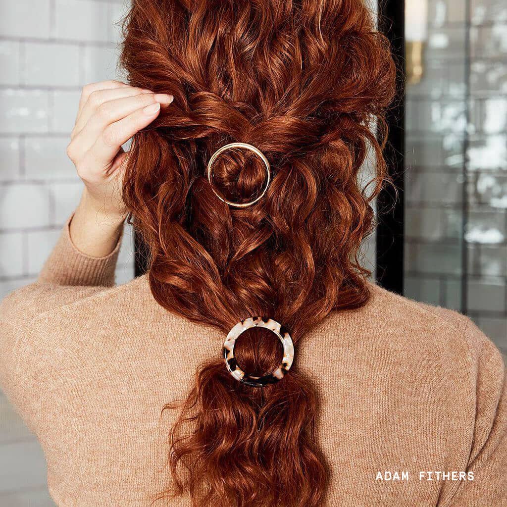Red hair woman standing in bathroom with two clips in ponytail